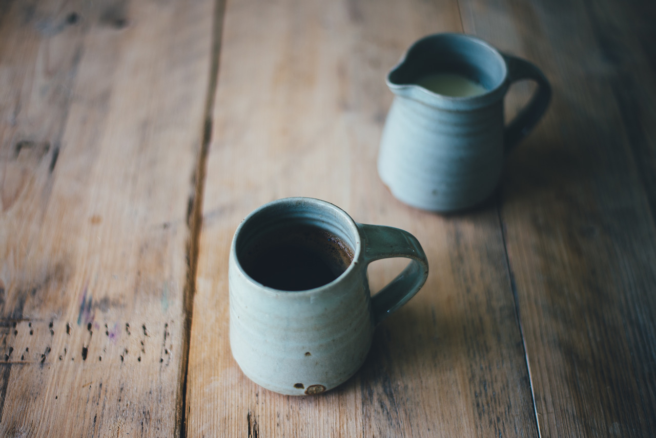 Two ceramic mugs on a wooden table